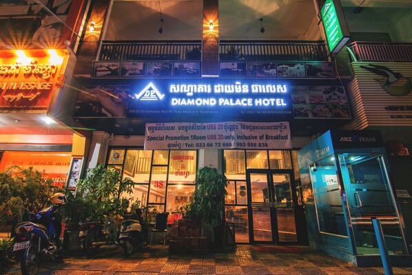 The exterior of the Diamond Palace Hotel with a sign indicating a special promotion for a room.