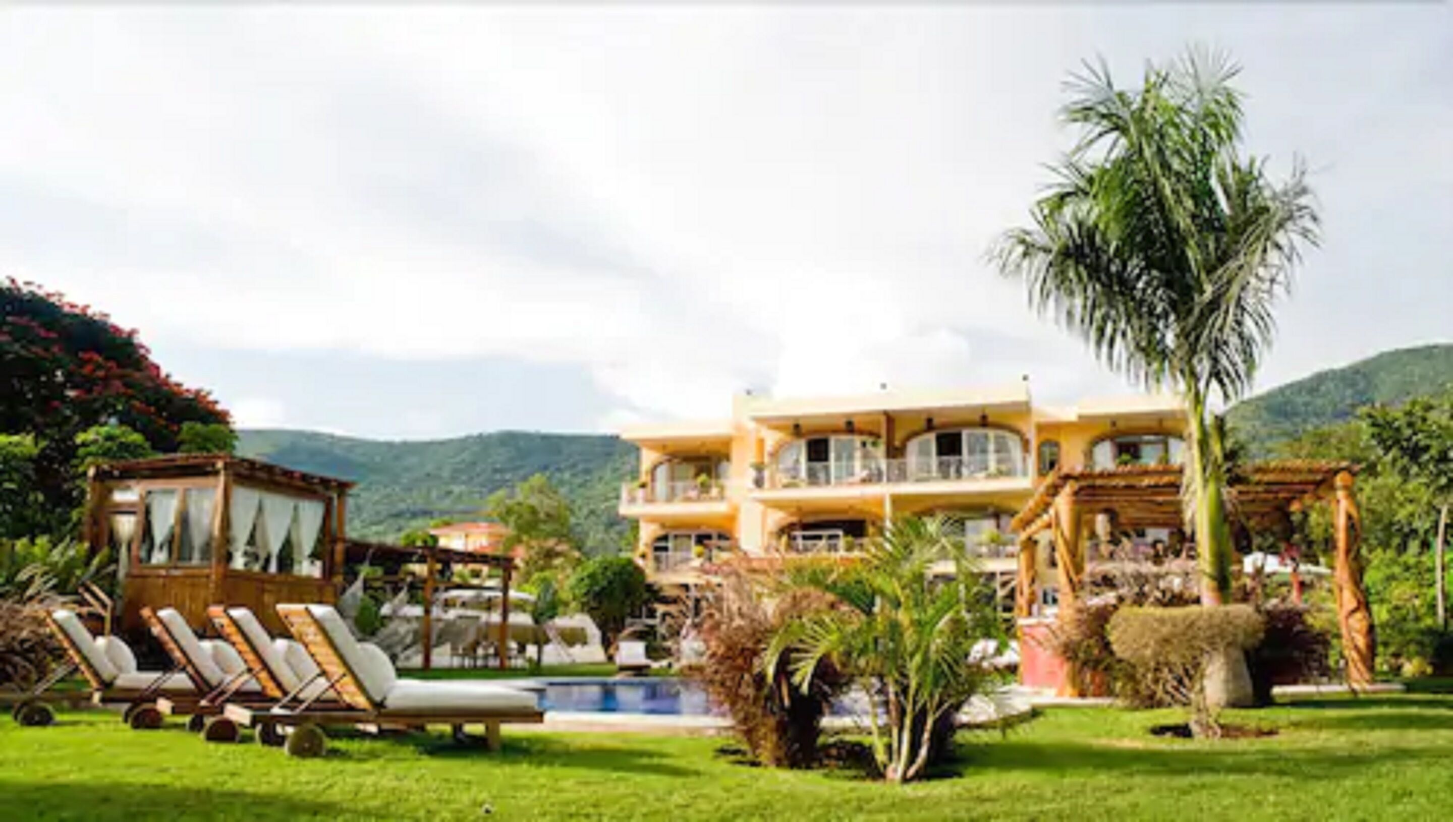 A large, multi-story building with a pool and outdoor seating area.