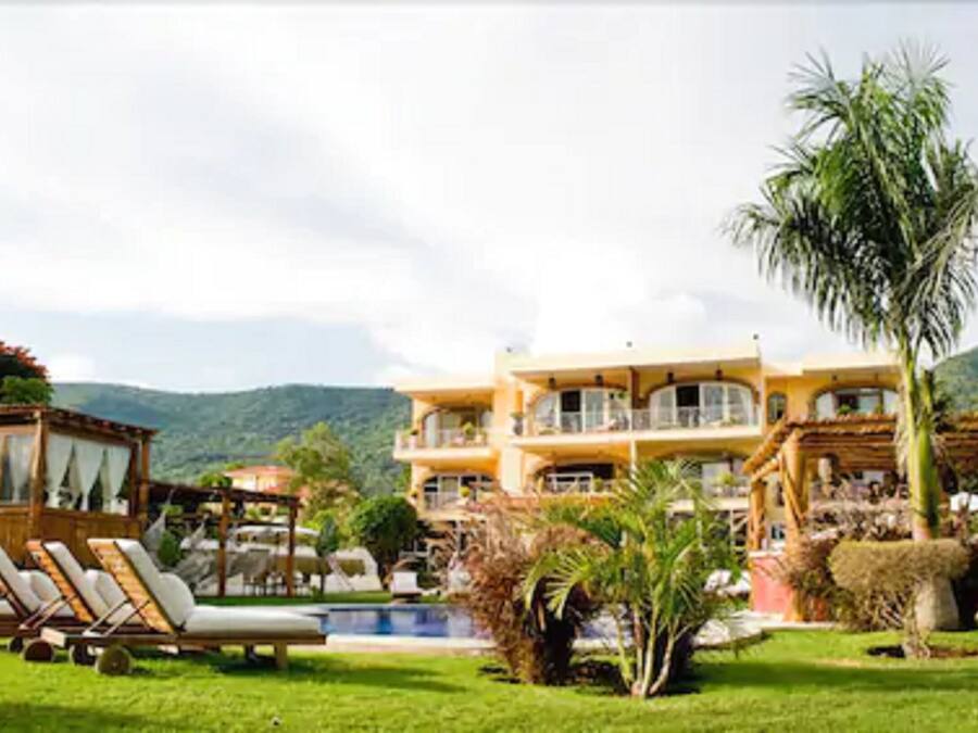 A large, multi-story building with a pool and outdoor seating area.