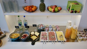 A breakfast buffet with various fruits, cheeses, meats, and beverages. - ibis Delemont Delsberg Hotel (Delemont)
