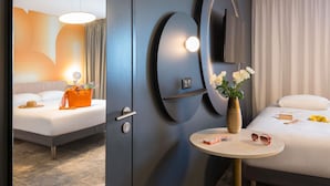 A hotel room with a bed, bedside table, and a wall-mounted TV. - ibis Styles Pertuis Luberon (Pertuis)