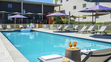 Una piscina al aire libre, sillones reclinables de piscina