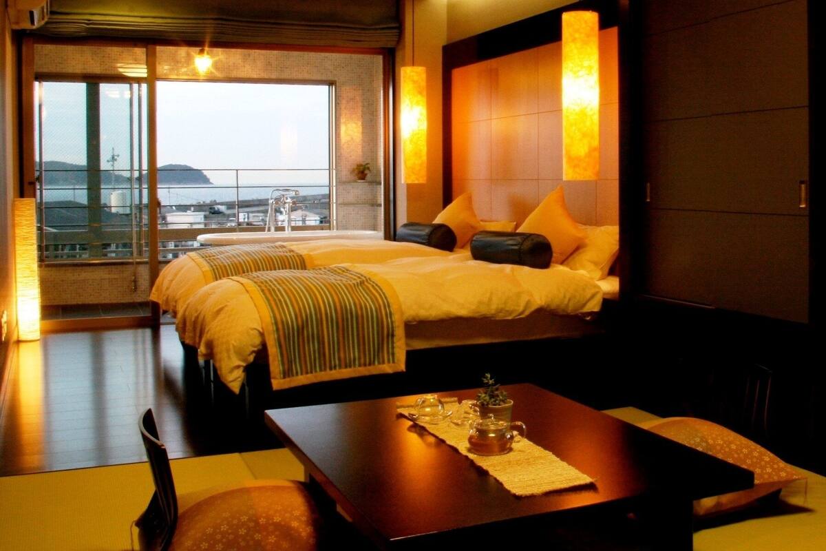 Ein Hotelzimmer mit Bett, Tisch und Blick auf die Stadt.