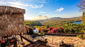 A thatched-roof structure with outdoor seating and a view of a mountainous landscape. - Hacienda Puerta Del Cielo Ecolodge & Spa (Nandasmo)