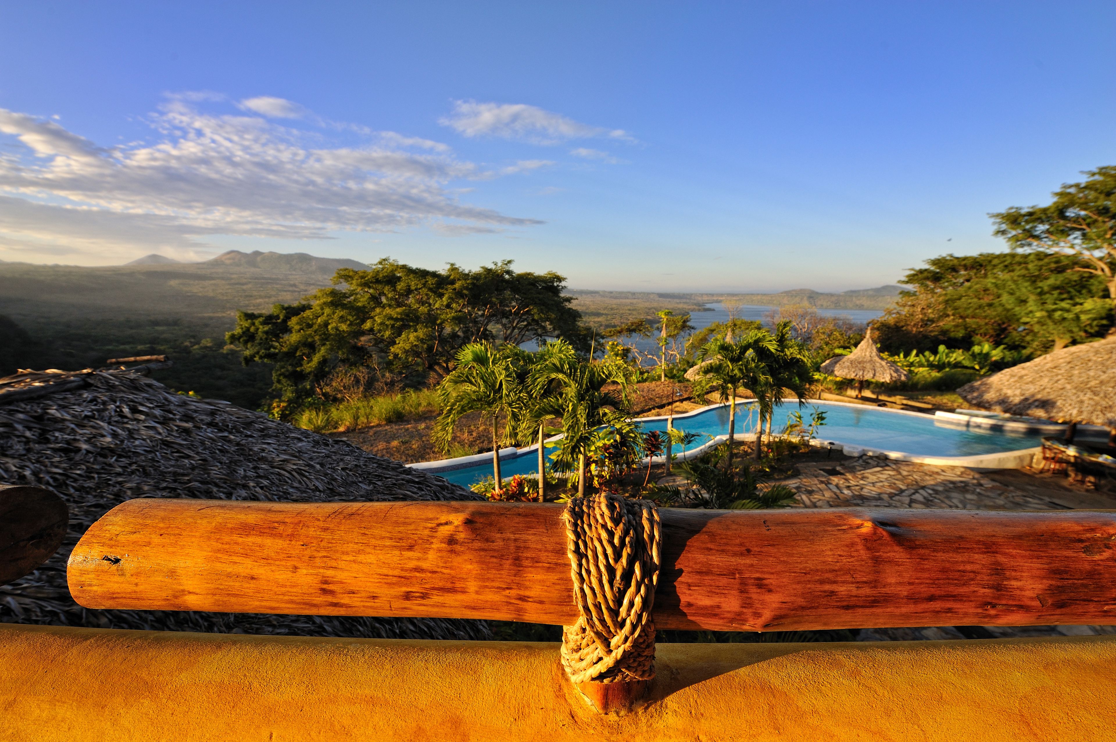 A pool area with a view of mountains and a clear sky.