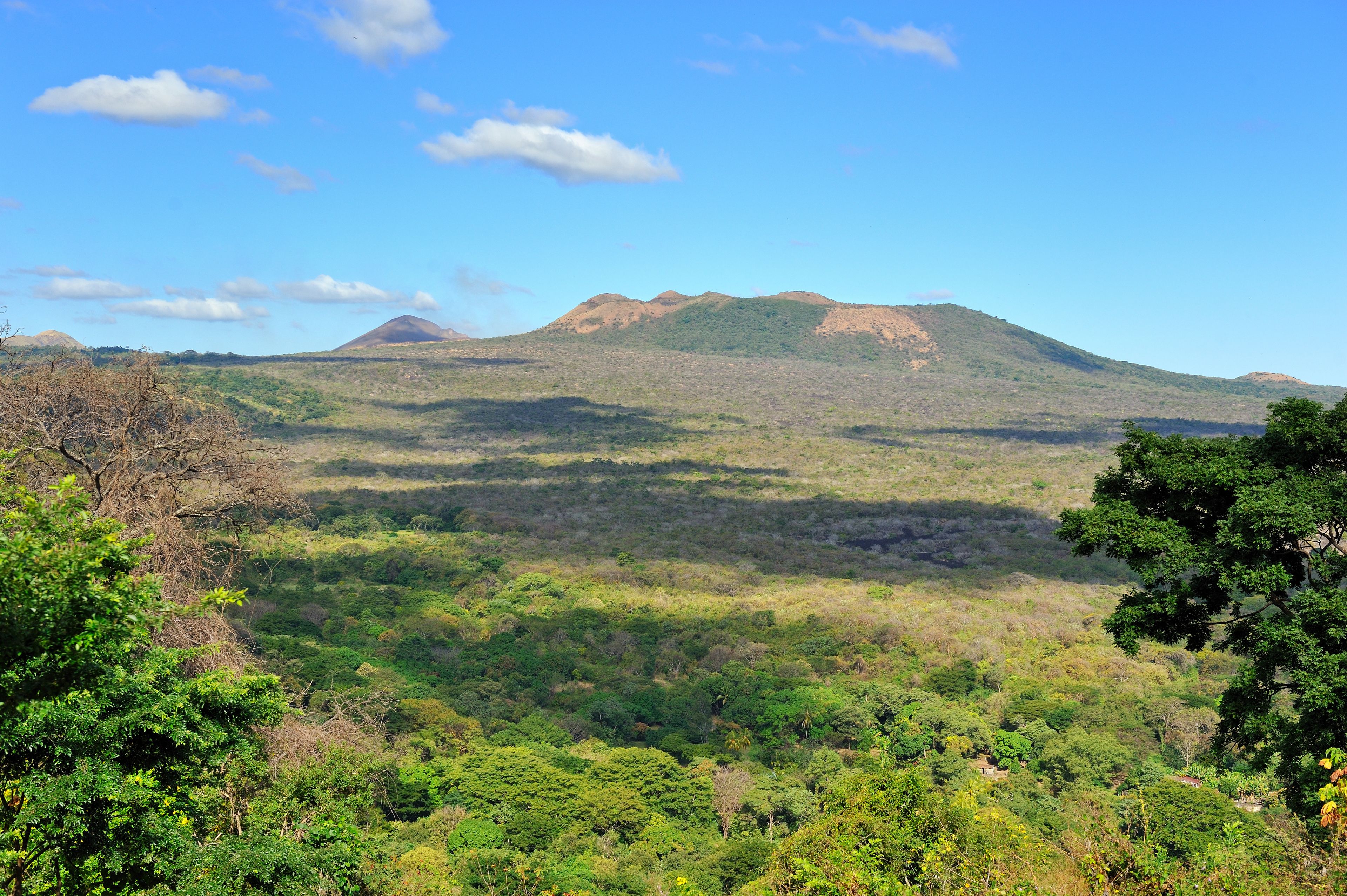 A mountainous landscape with dense forest and clear skies.
