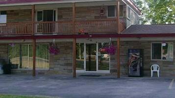 A two-story building with a balcony, a satellite dish, and a small porch area.