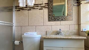 A bathroom with a toilet, sink, and shower.