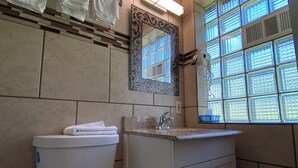 Ein Badezimmer mit Toilette, Waschbecken und einem Spiegel mit Zierrahmen.