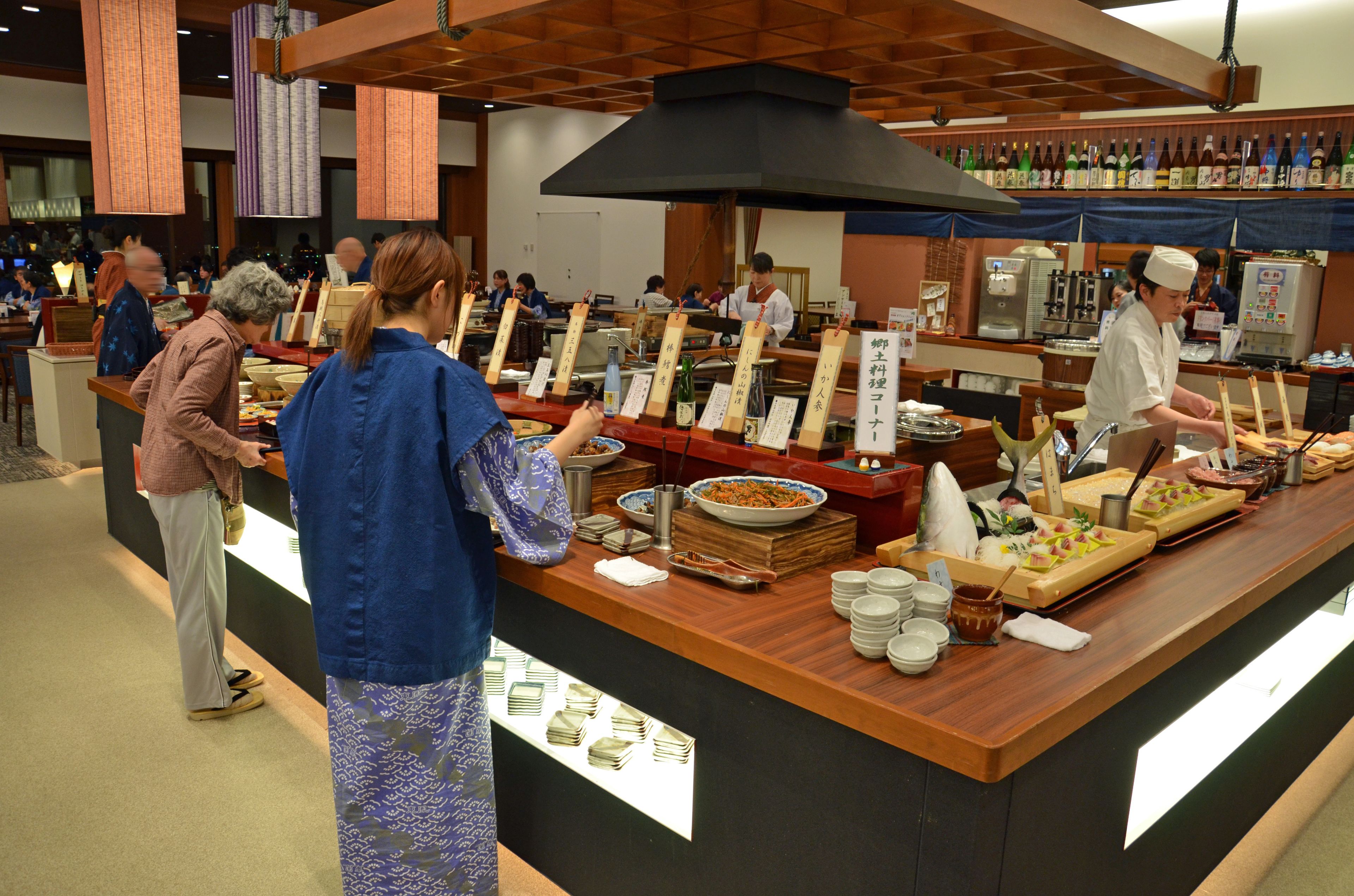 Un'area buffet con diversi cibi e un banco dove il personale serve i clienti.