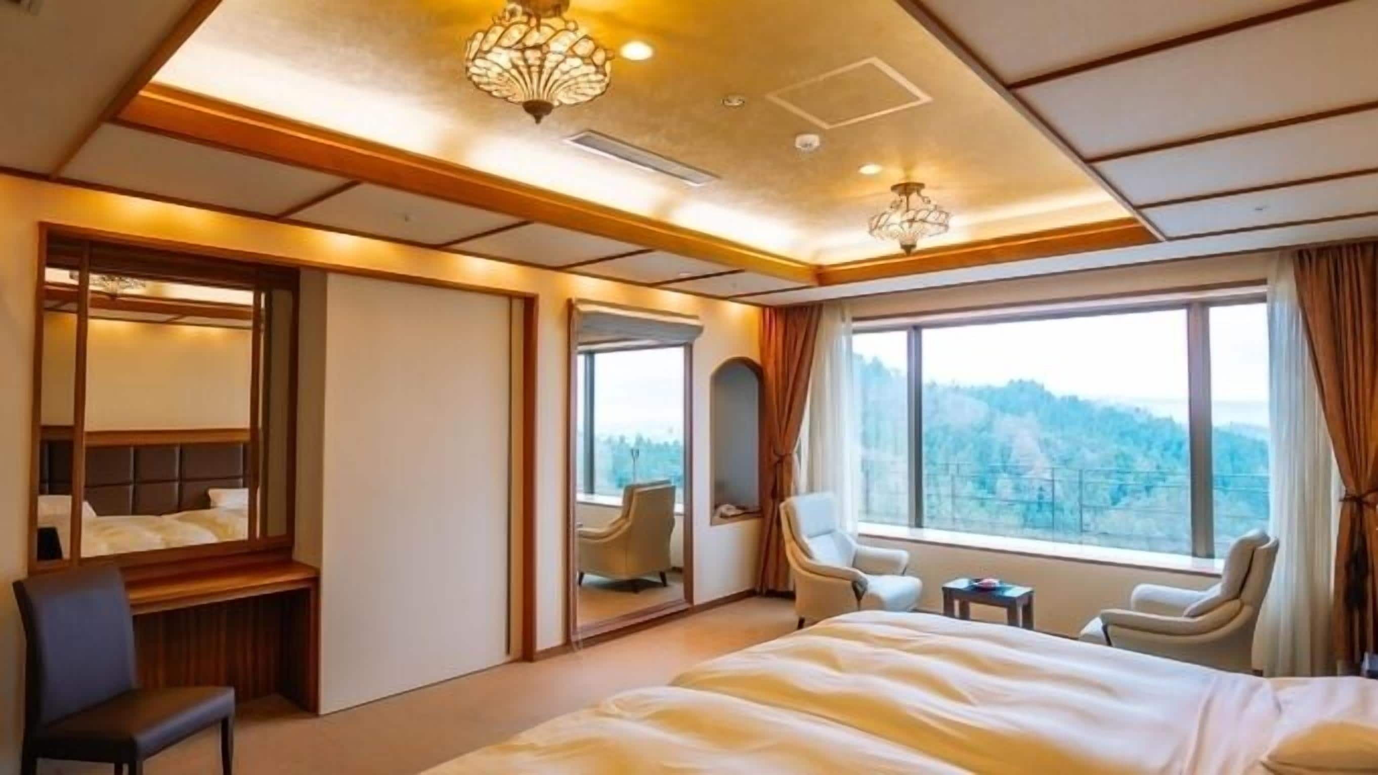 Habitación de hotel con una cama grande, un escritorio, dos sillas, un espejo y vistas al exterior.