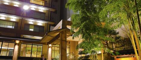 A multi-story hotel with a modern design, featuring a prominent entrance with steps and a covered area.