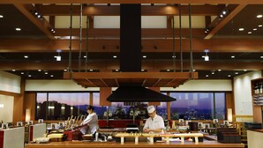 A restaurant with a high ceiling, wooden beams, and a view of the cityscape through large windows. - Onyado Toho（ORIX HOTELS & RESORTS） (Aizuwakamatsu)