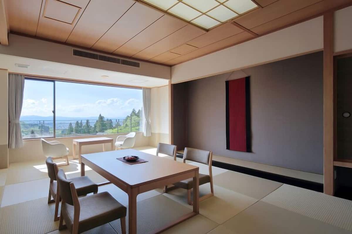A modern room with a large window, a wooden table, and tatami mats.