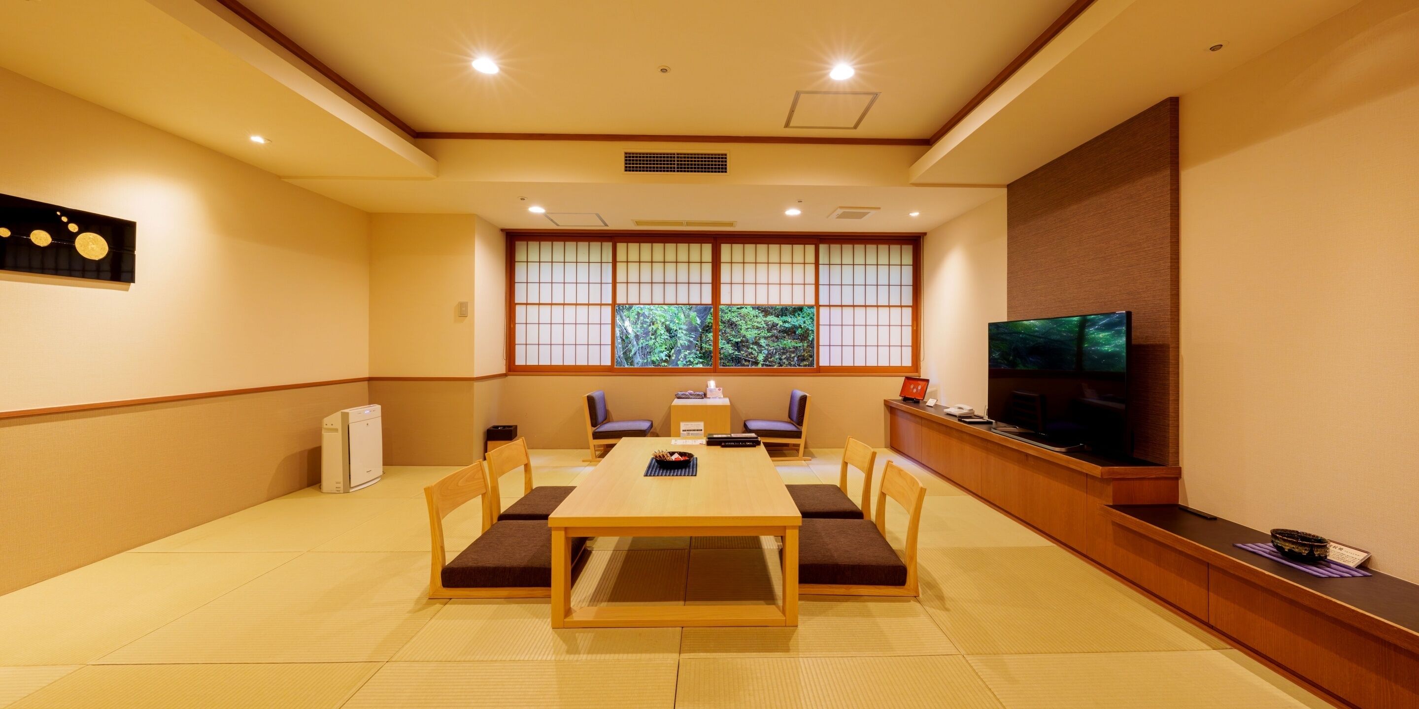A traditional Japanese-style room with tatami flooring, a low table, and cushions.