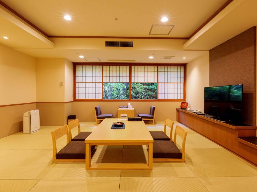 Une pièce de style japonais traditionnel, avec un sol recouvert de tatamis, une table basse et des coussins.