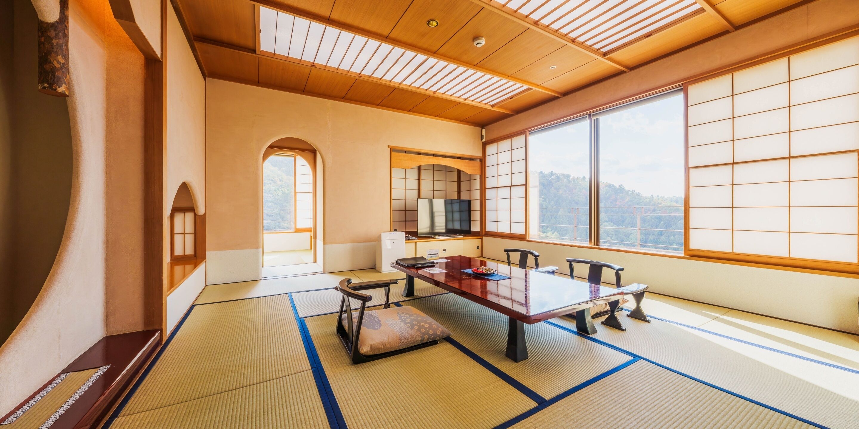 A traditional Japanese room with tatami flooring, a low table, and sliding doors.