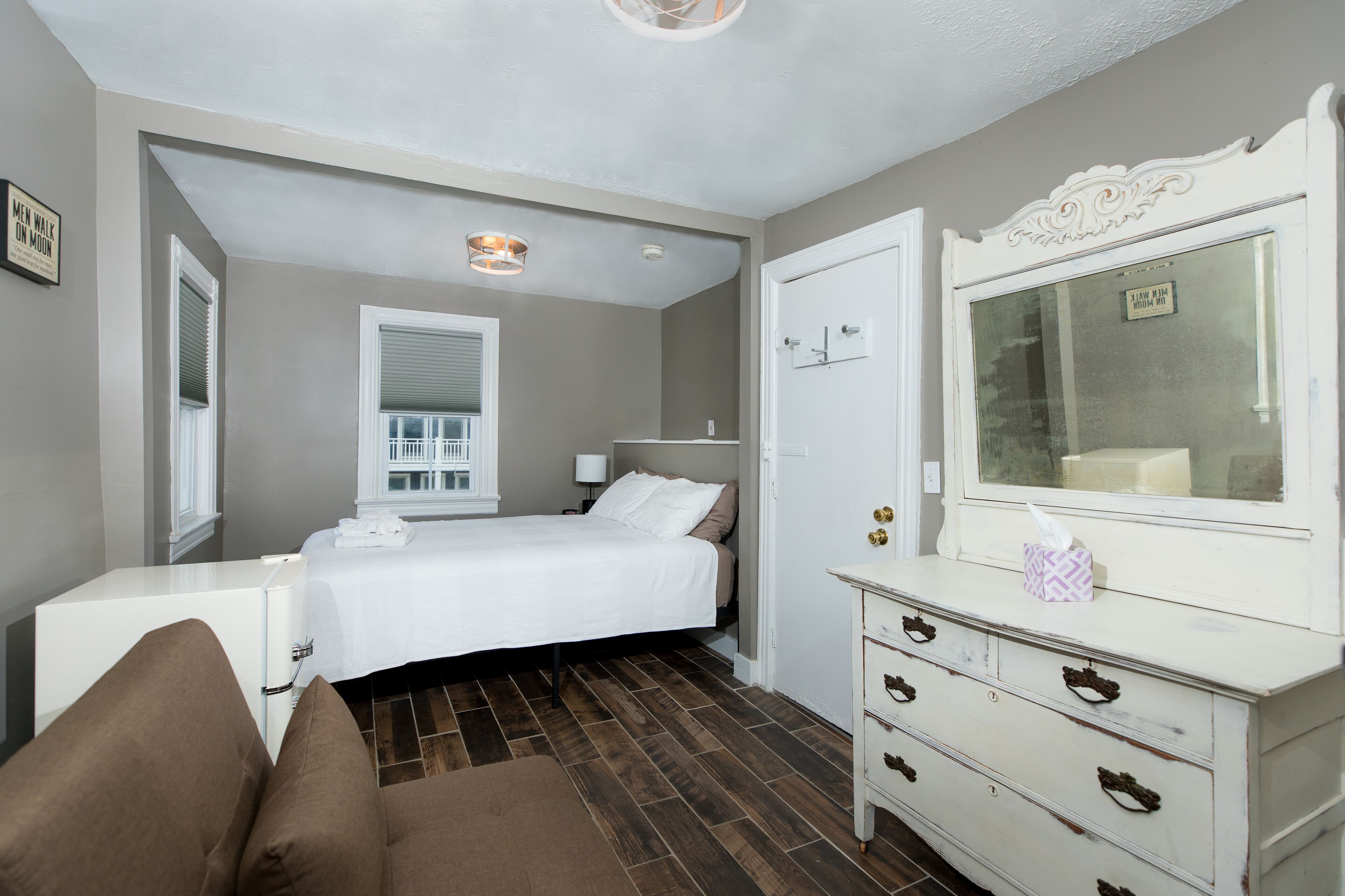 Une chambre à coucher avec un lit, une commode et un miroir.