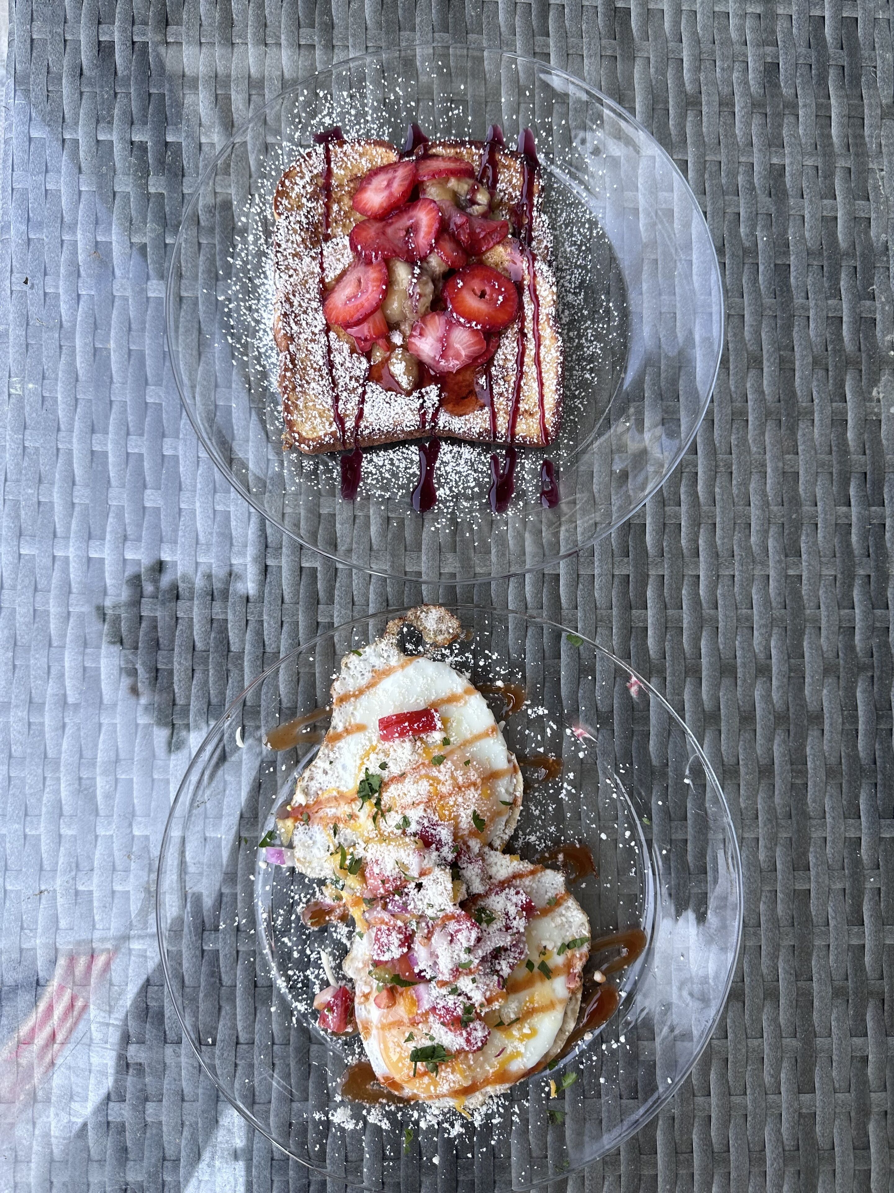 Two dishes on clear glass plates with a woven mat background.