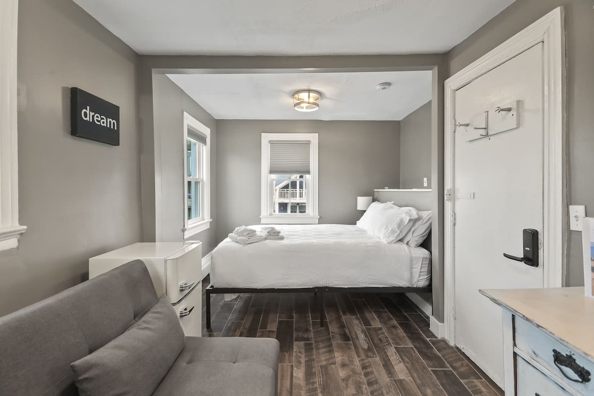 A bedroom with a bed, bedside table, and a wall-mounted sign.