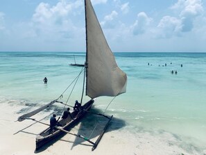 Am Strand, weißer Sandstrand, Sonnenschirme, Strandtücher