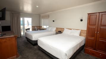 A hotel room with two beds, a desk, a TV, and a wardrobe.