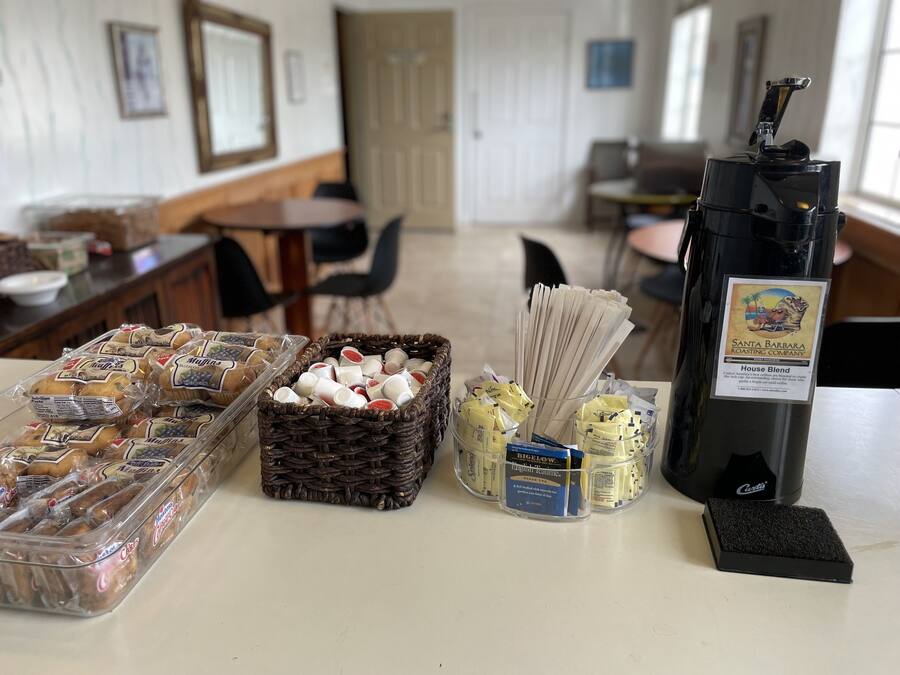 A breakfast buffet with muffins, pastries, and coffee options.