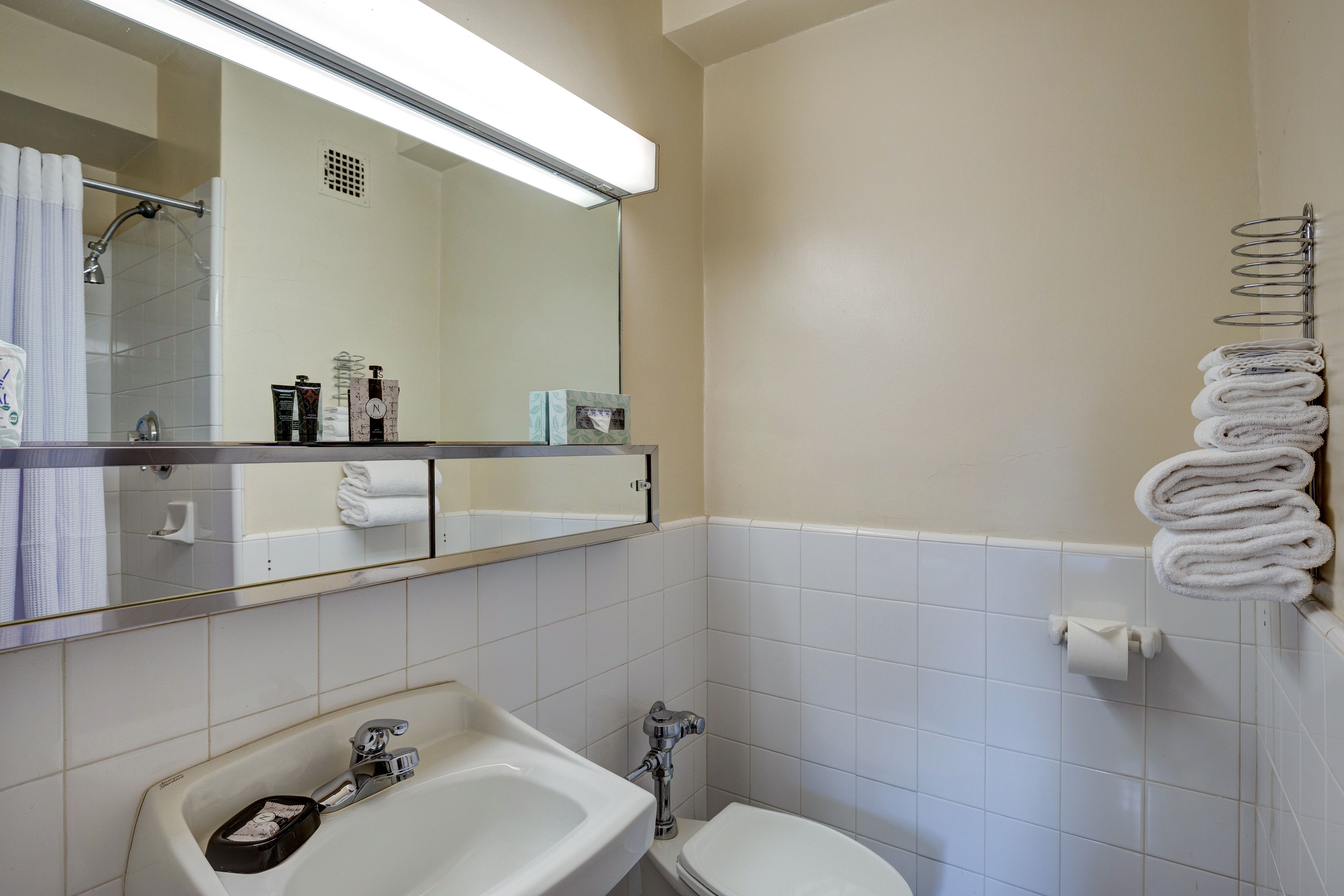 A bathroom with a sink, toilet, and a mirror above the sink.