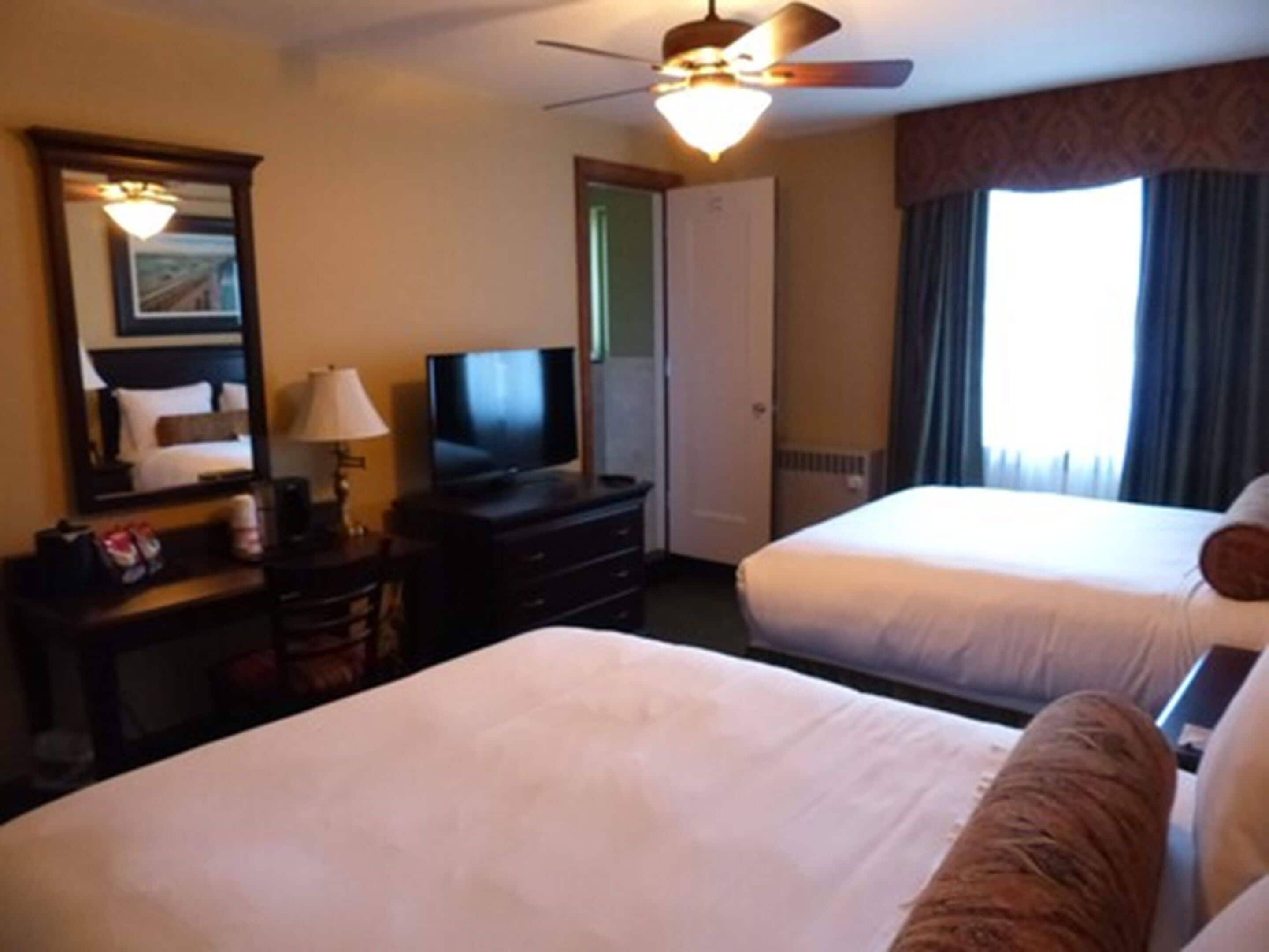 deluxe room, 2 queen beds, non smoking | premium bedding, desk, iron/ironing board, free cots/infant beds