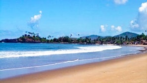 Una playa con cielos despejados y aguas tranquilas.