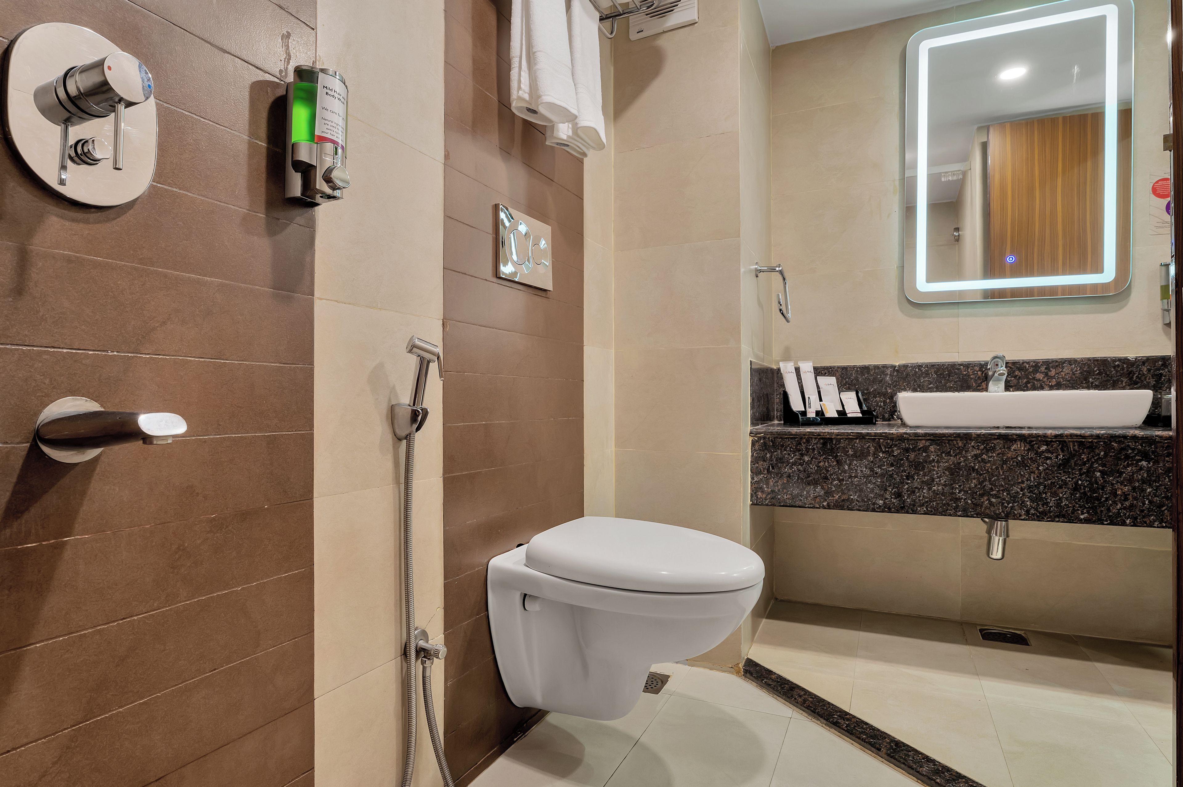 A modern bathroom with a toilet, shower, and sink.