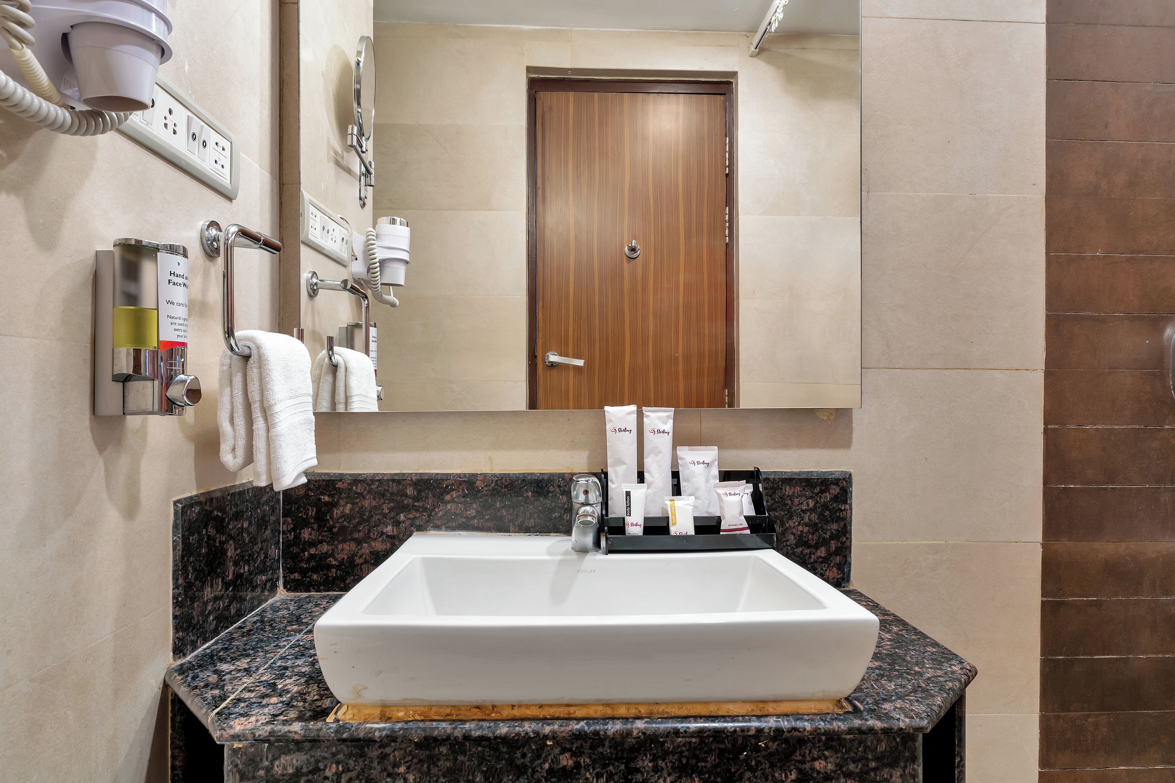 A bathroom with a white sink, a mirror, and a towel rack.