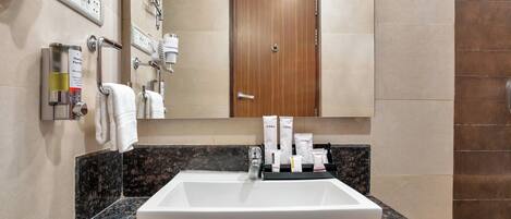 A bathroom with a white sink, a mirror, and a towel rack.