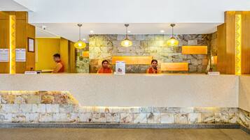A reception desk with a stone wall backdrop, a wooden panel design, and a sign indicating a sanitized pen area.