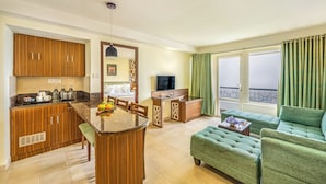 A compact living space with a kitchen, dining area, and a balcony with curtains.