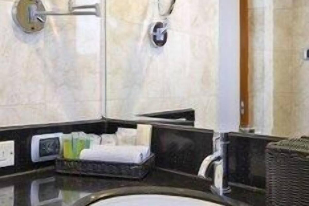 Een badkamer met een grote spiegel, een wastafel en een handdoekhouder.
