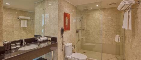 A modern bathroom with two sinks, a toilet, and a glass-enclosed shower.