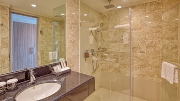 Une salle de bain moderne avec un lavabo en marbre, une douche en verre et un grand miroir.