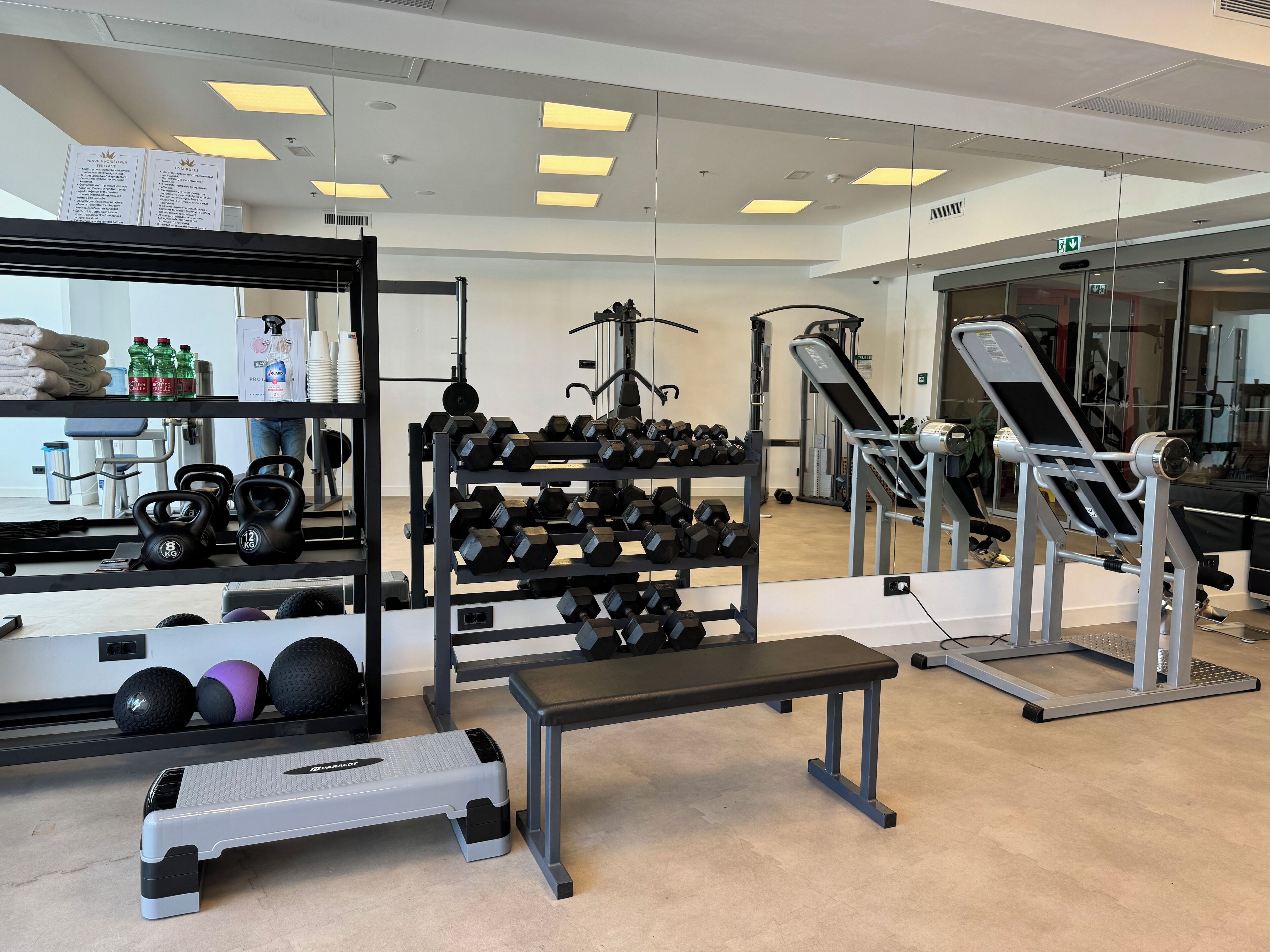 A gym with exercise equipment, a step platform, and a bench.