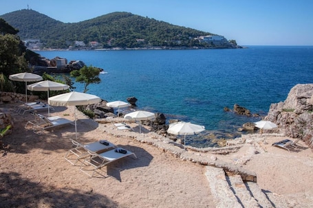 On the beach, sun loungers, beach umbrellas, beach towels. Hotel Royal Ariston
