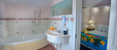 A bathroom with a bathtub, sink, and shower.