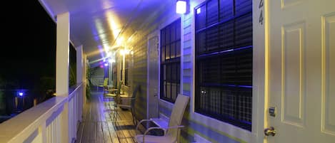 A covered porch with a white railing, a bench, and a door marked "524".