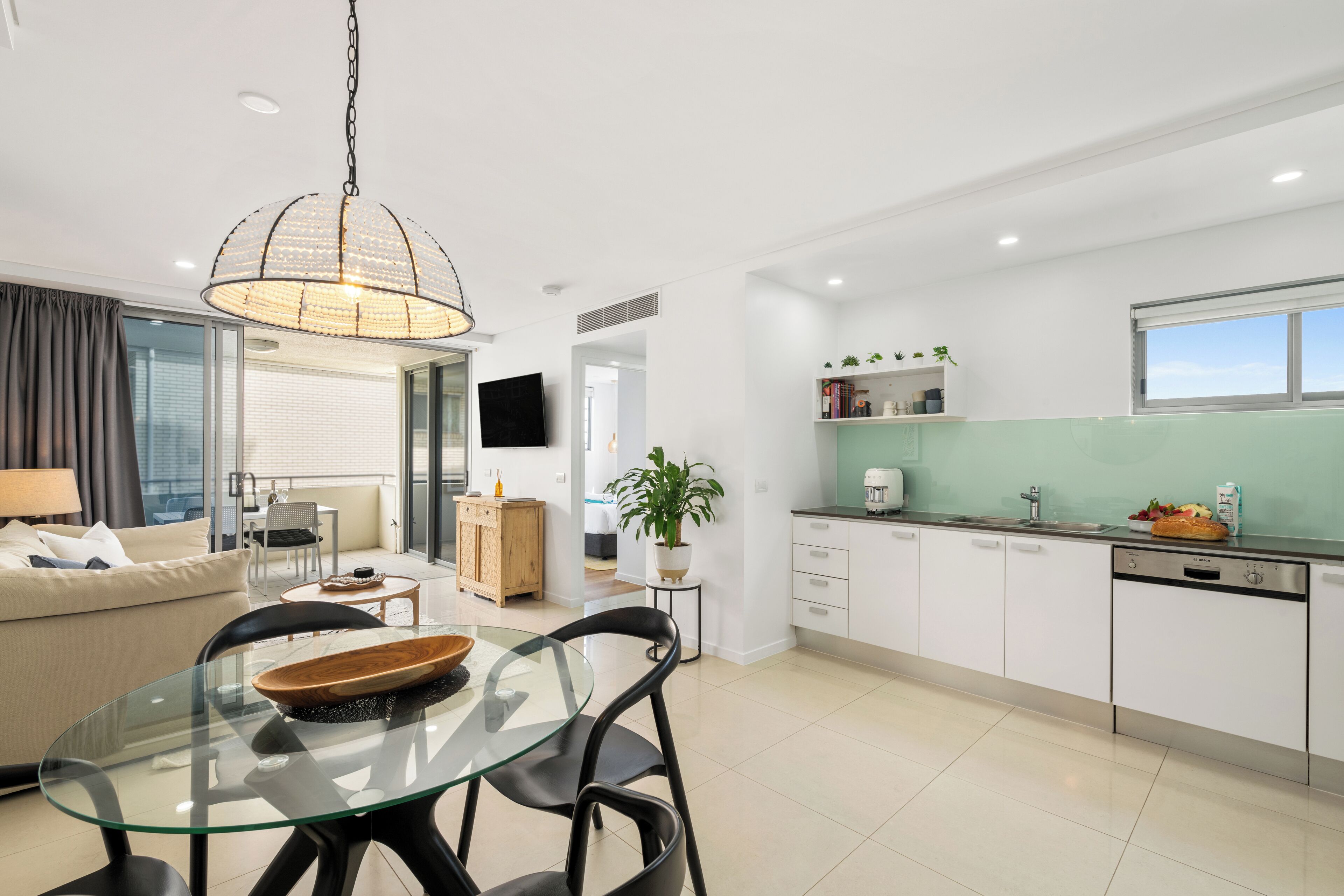 A modern apartment with a dining area, kitchen, and living room.