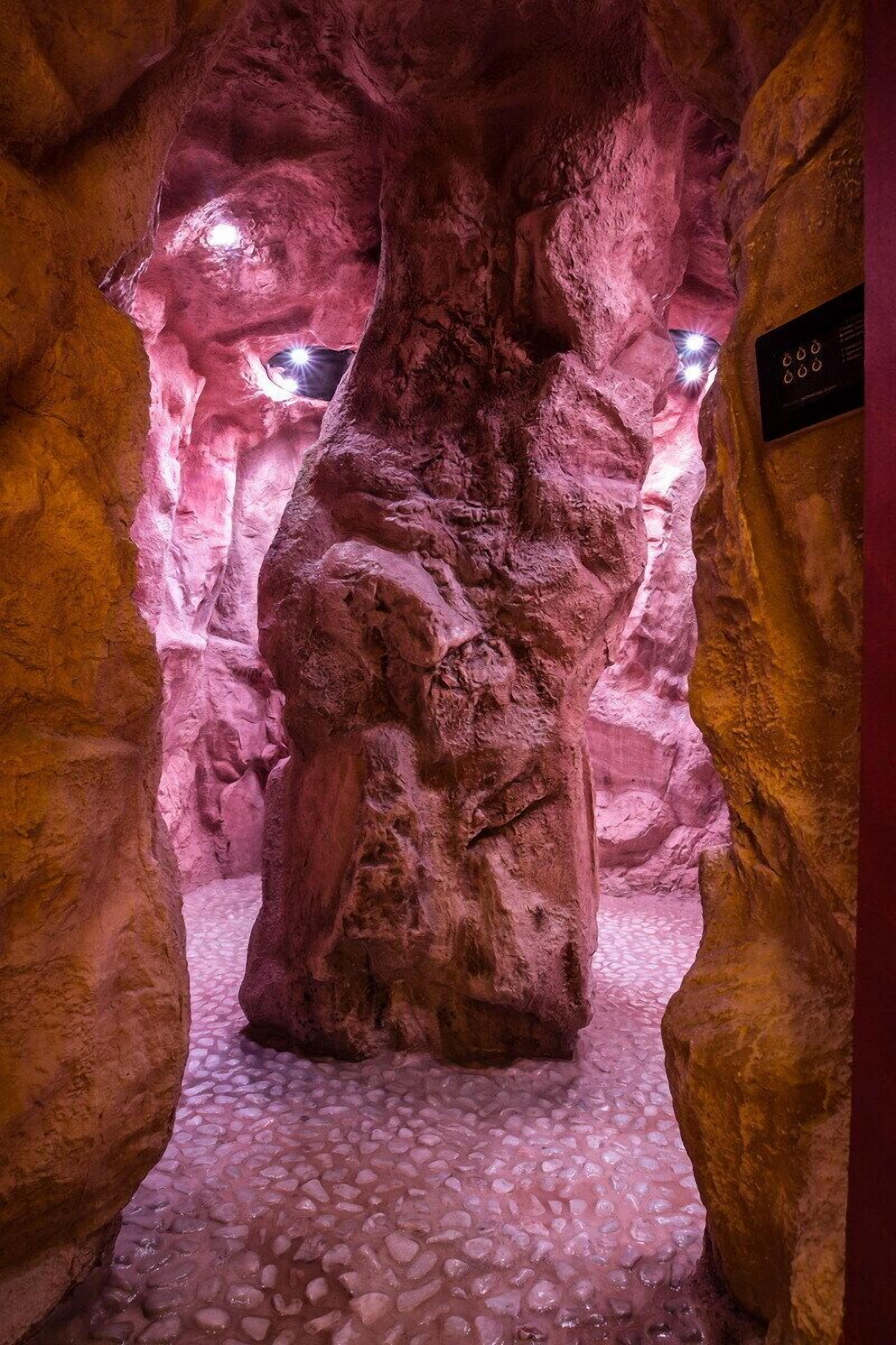 Eine Höhle mit einer großen Felsformation und einem Schild an der Wand.