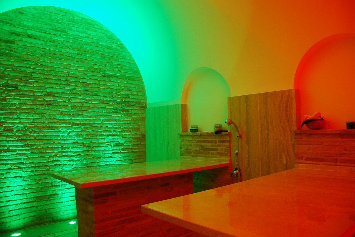 A spa area with a stone wall, wooden benches, and a wooden counter.
