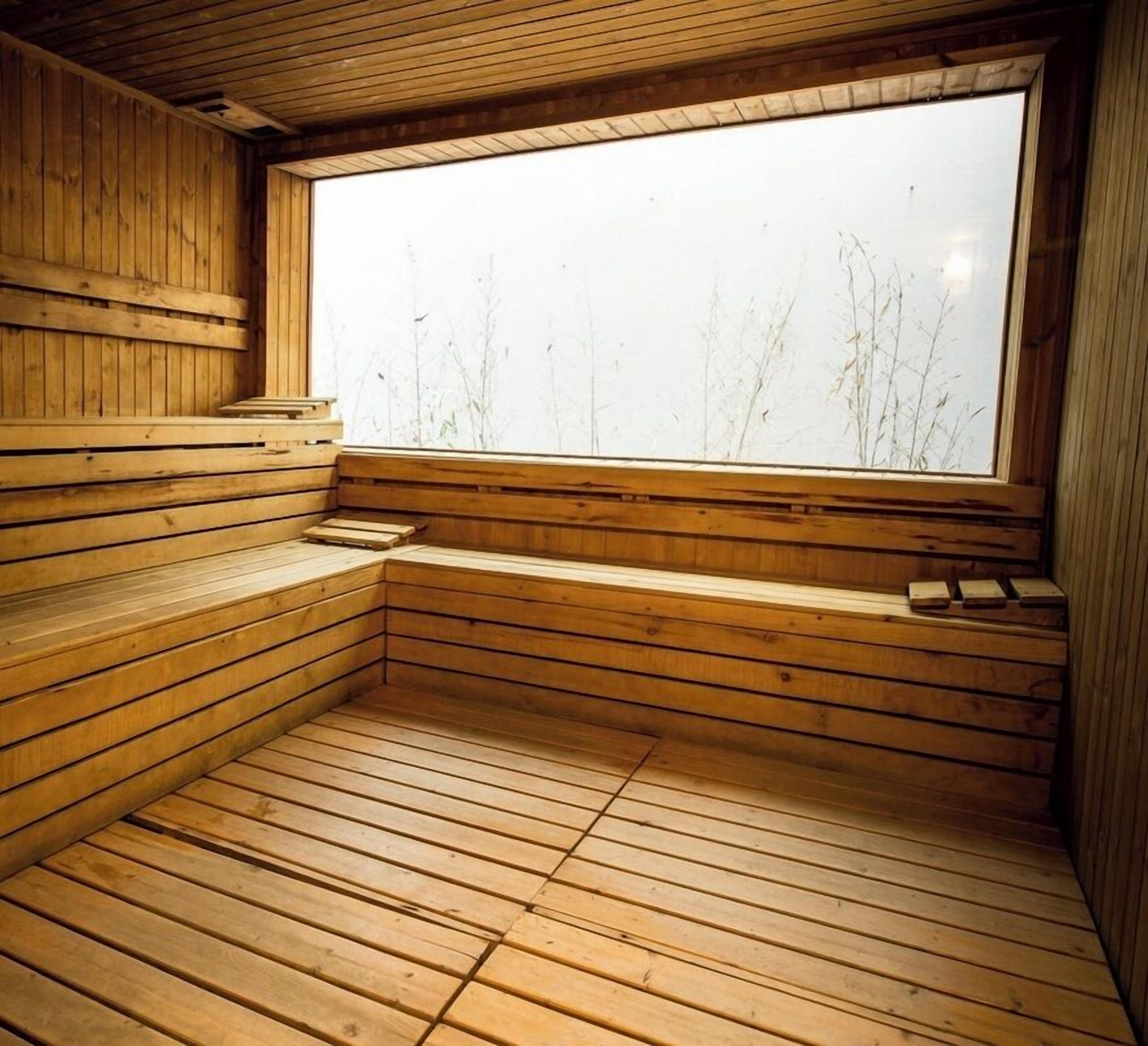 A sauna with wooden benches and a large window.