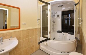 A bathroom with a white bathtub, a sink, and a mirror.