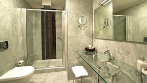 A modern bathroom with a glass shower enclosure, a glass sink, and a large mirror. - Town House Cavour (Reggio Calabria)