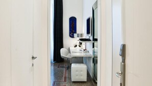 A hallway leading to a bedroom with a bed, a desk, and a chair. - Town House Cavour (Reggio Calabria)