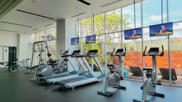 A gym with treadmills, elliptical machines, and weight equipment.